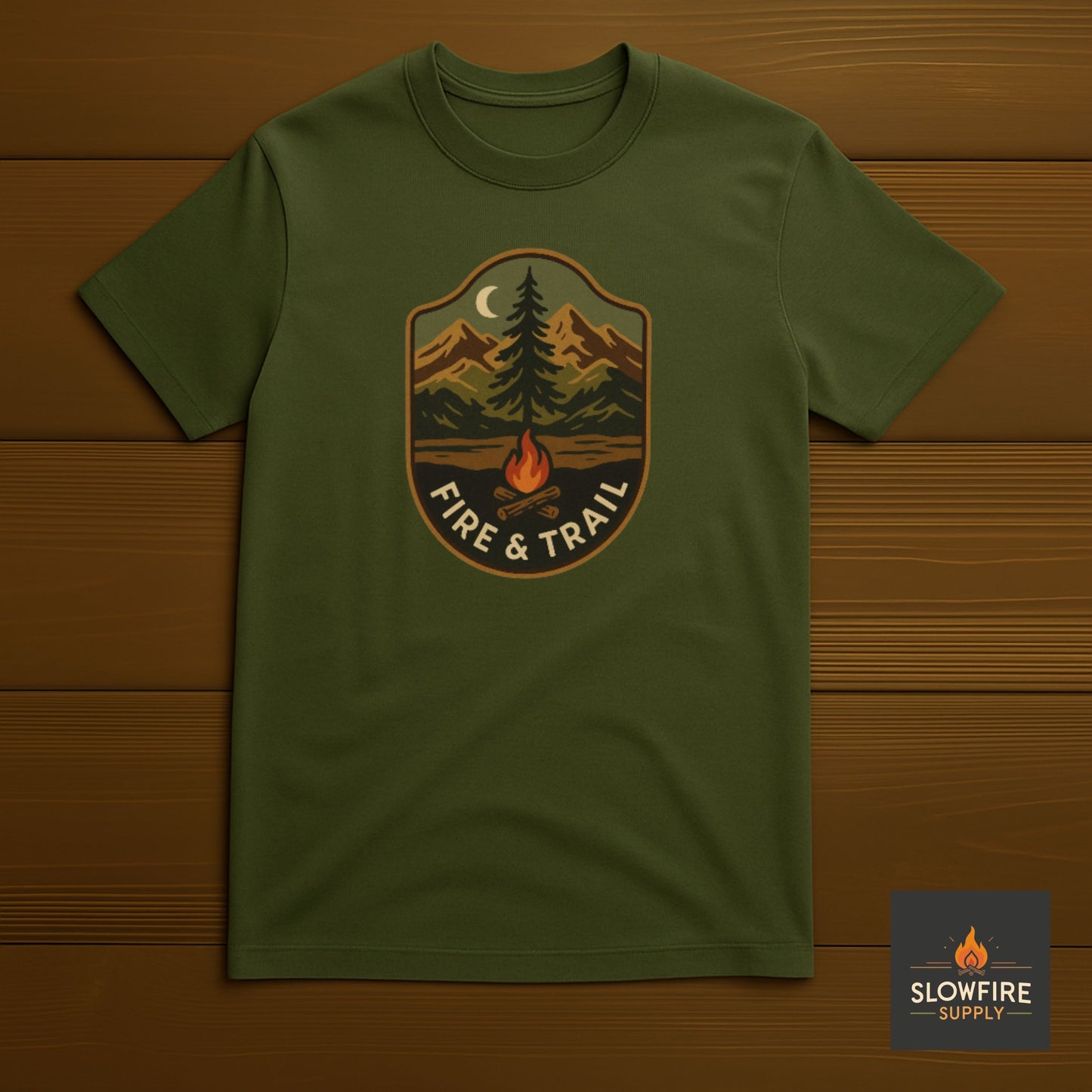 Green t-shirt with 'Fire & Trail' design on a wooden background