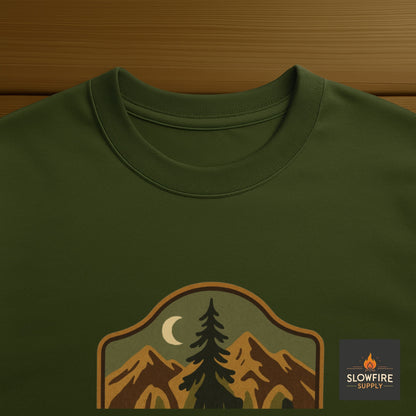 Green t-shirt with nature-themed graphic and 'Slowfire Supply' logo on a wooden surface