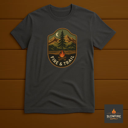Dark gray t-shirt with 'Fire & Trail' graphic on a wooden background