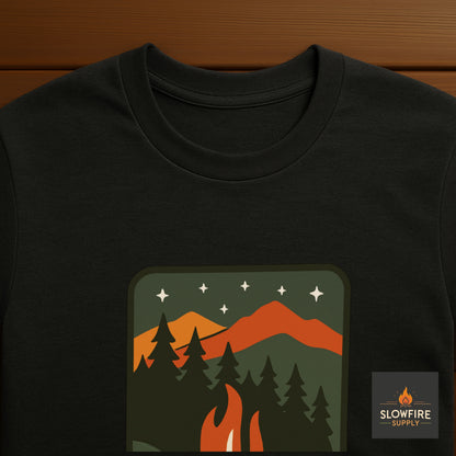 Black t-shirt with a nature-themed graphic and 'Slowfire Supply' logo on a wooden surface