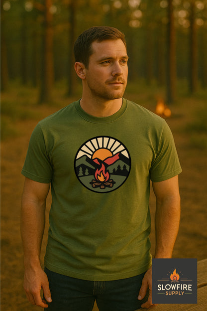 Man wearing a green t-shirt with a logo in a forest setting, featuring the Slowfire Supply brand.