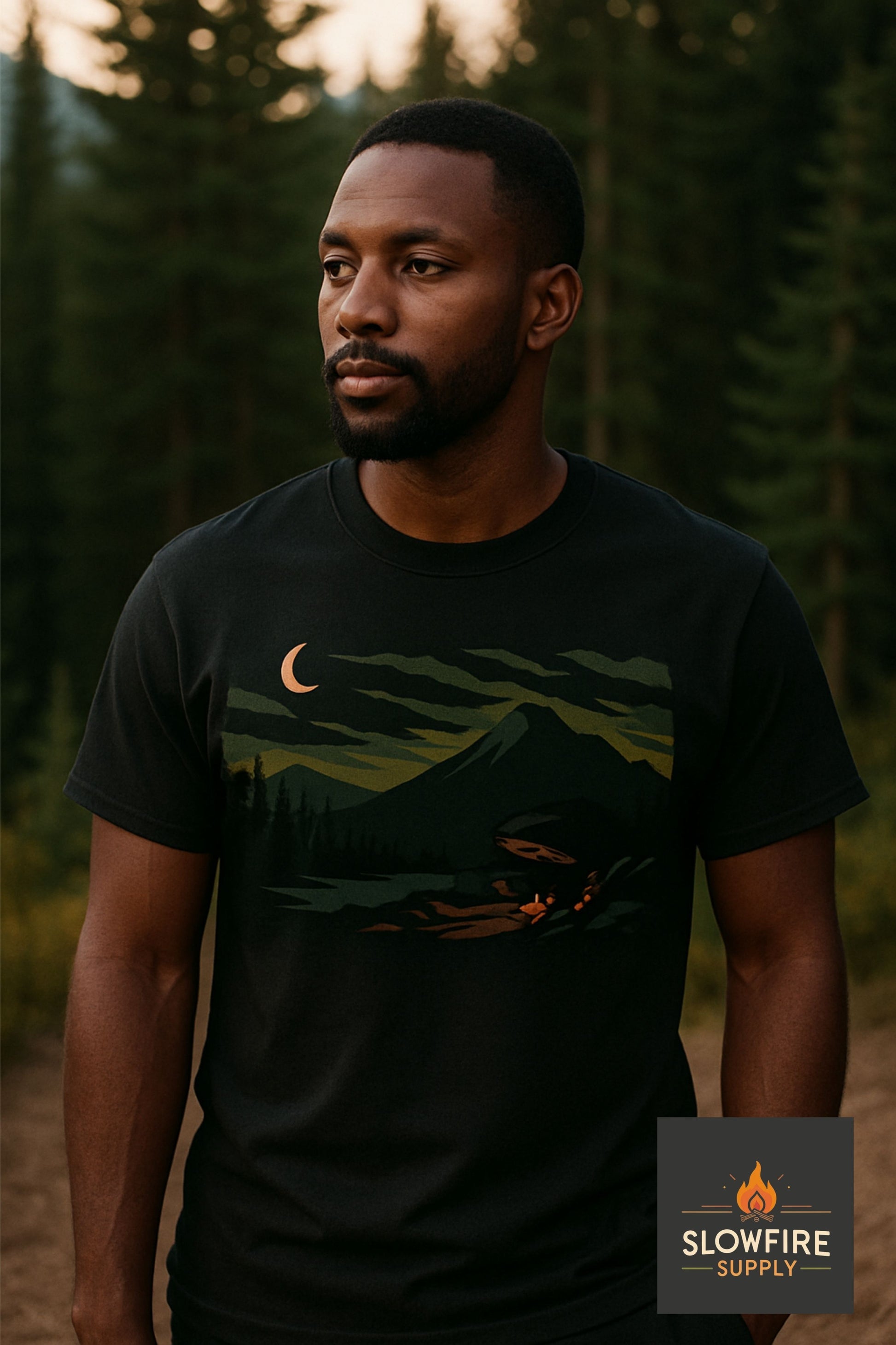 Man wearing a black t-shirt with a nature graphic in a forest setting, featuring the Slowfire Supply logo.
