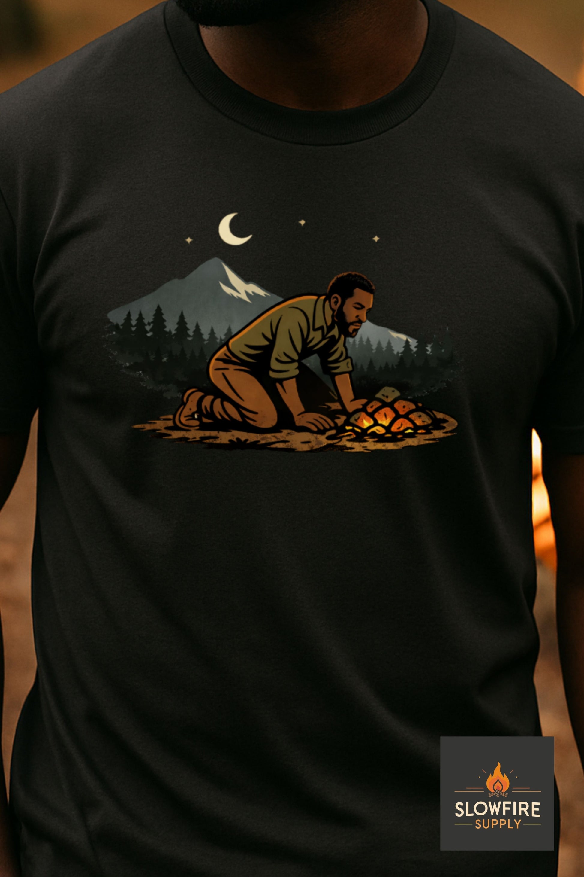 Black t-shirt with a graphic of a person lighting a fire in the woods, featuring the brand 'Slowfire'.
